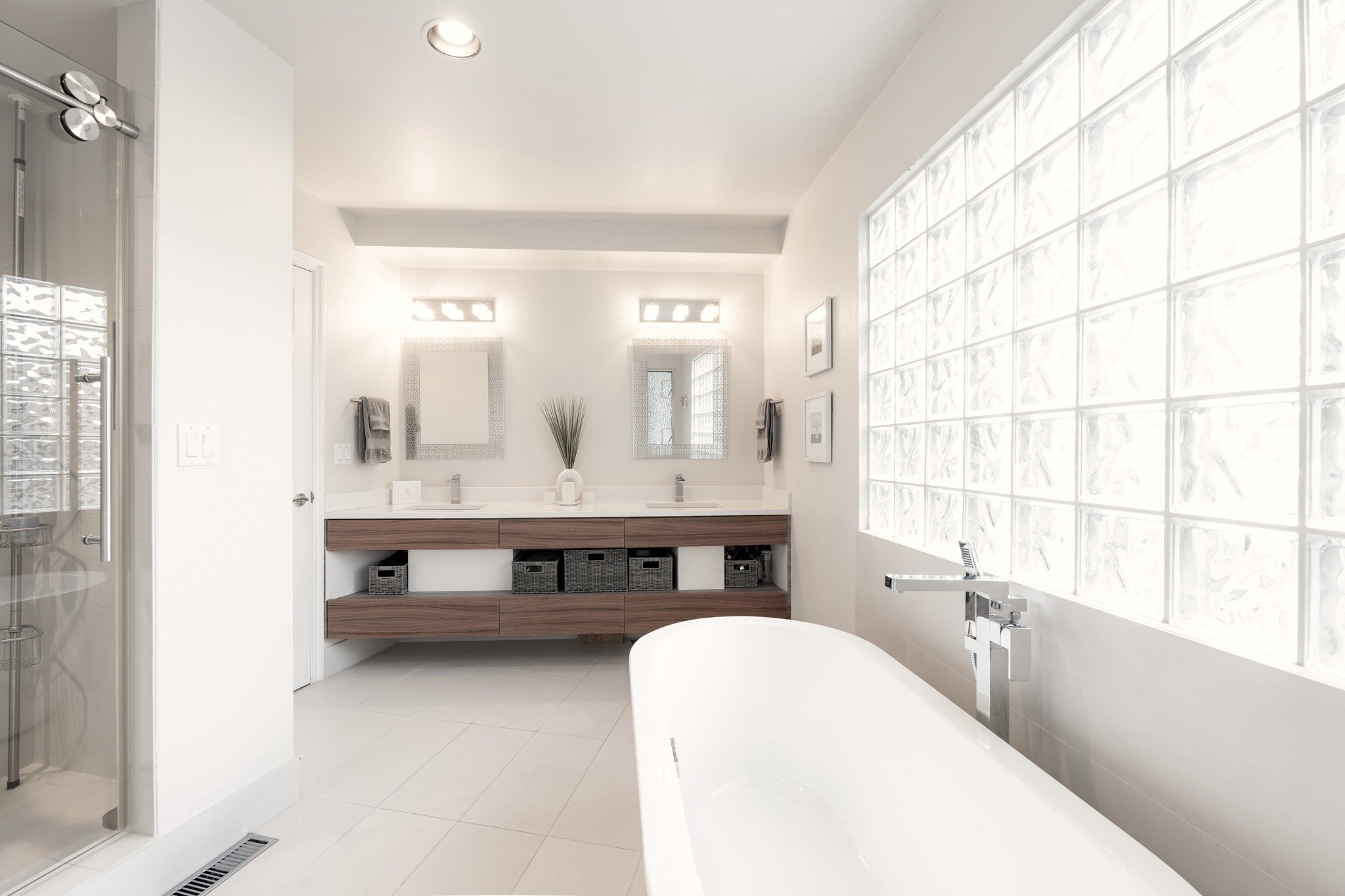 Bright spa-style bathroom with freestanding tub and glass-block windows